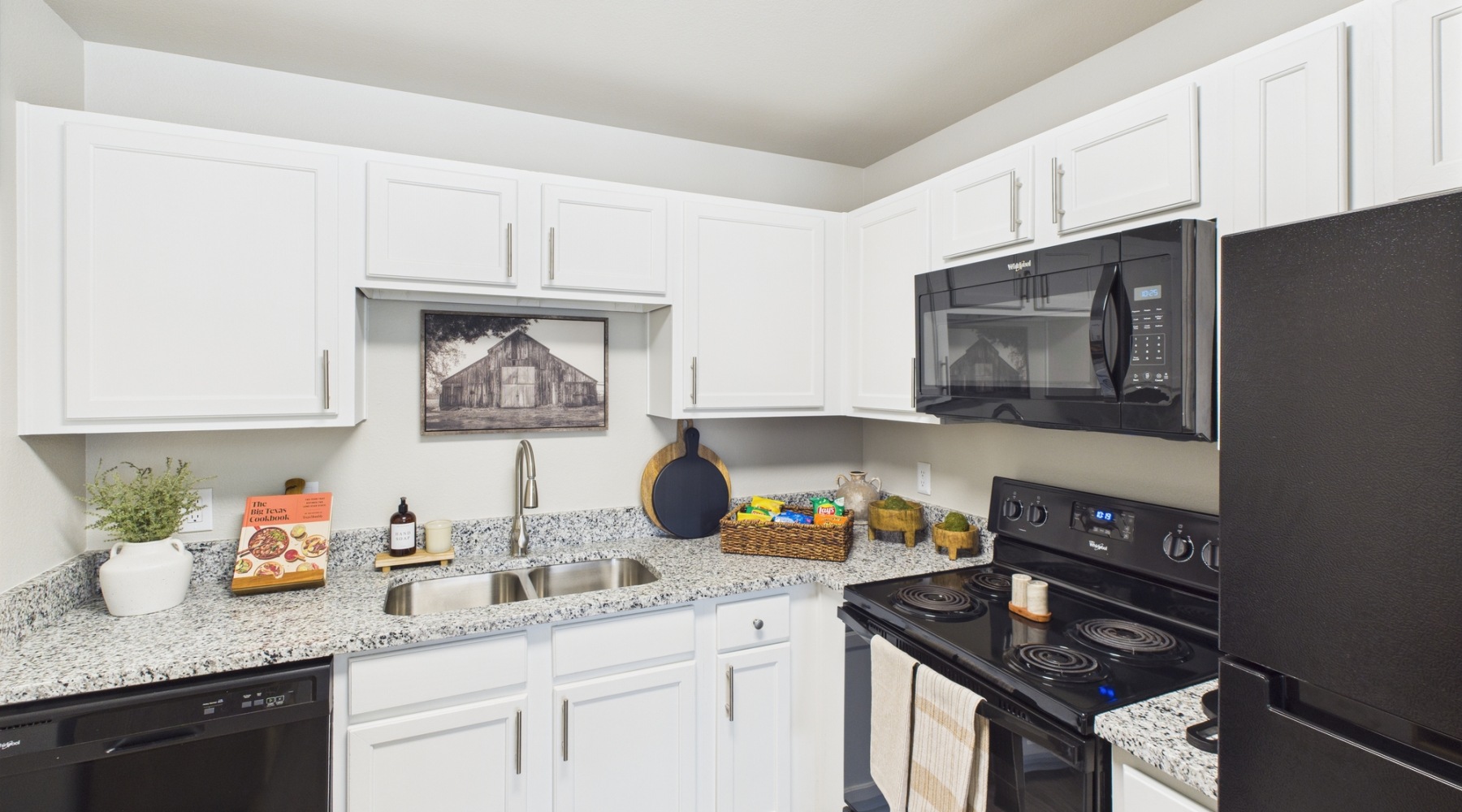 Styled kitchen with white cabinets and black appliances
