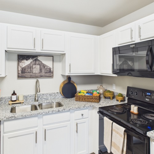 Styled kitchen with white cabinets and black appliances
