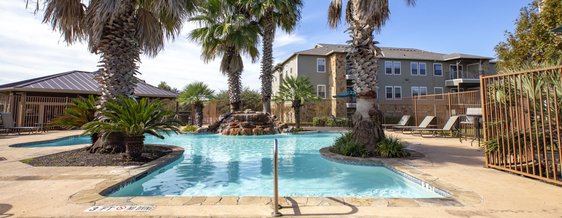 Apartment pool surrounded by palm trees